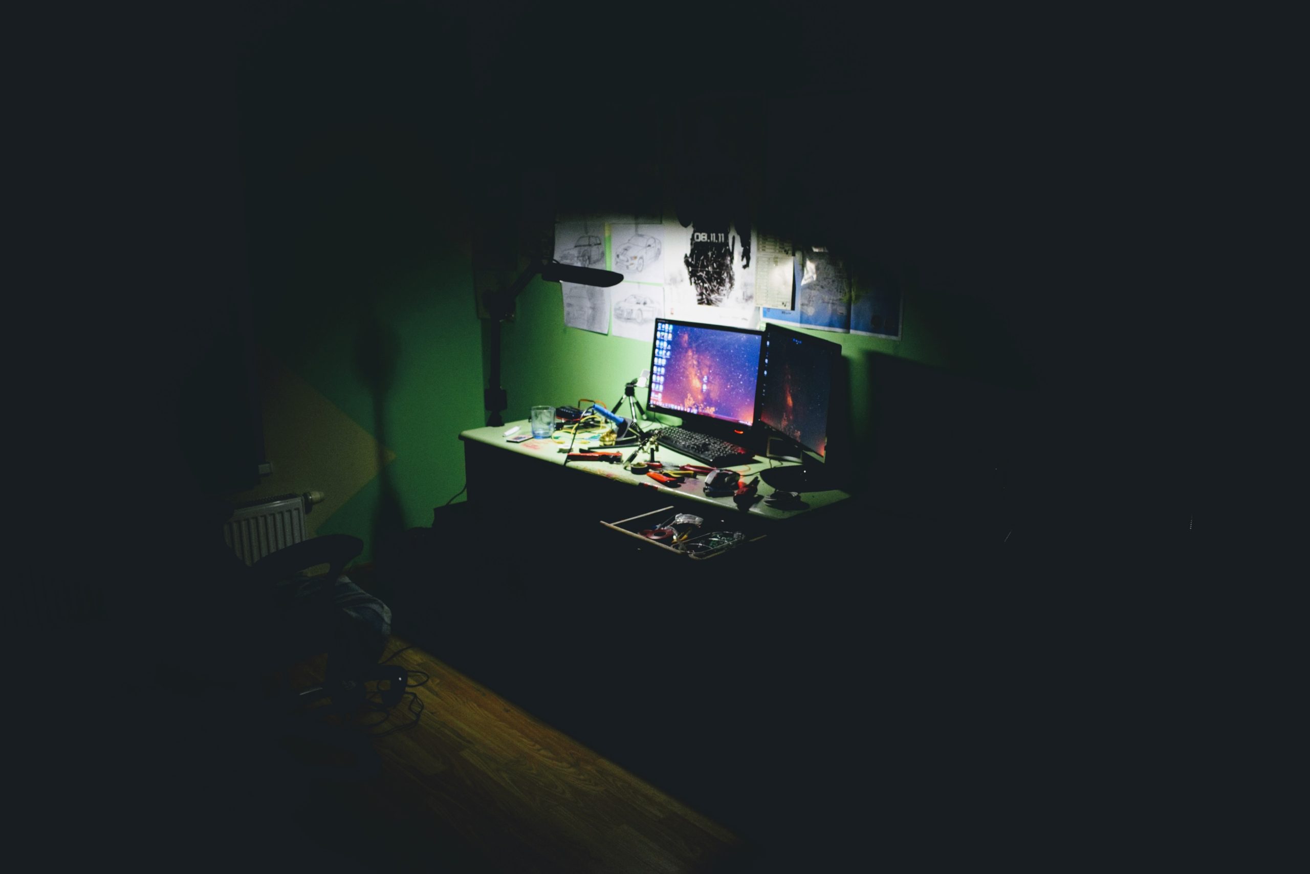 A desktop computer in a dark bedroom